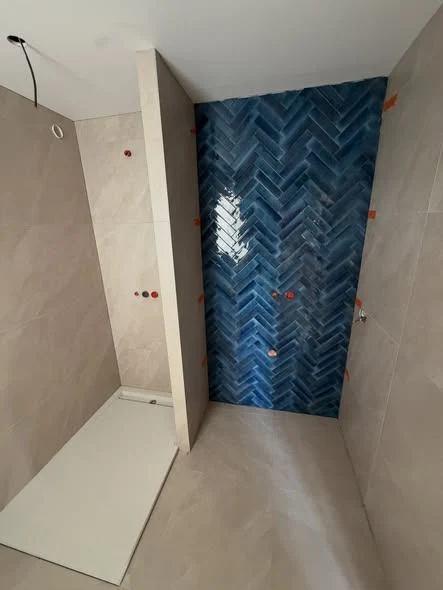 Salle de bains à Viuz-en-Sallaz avec carrelage clair et décor bleu effet zellige en chevrons