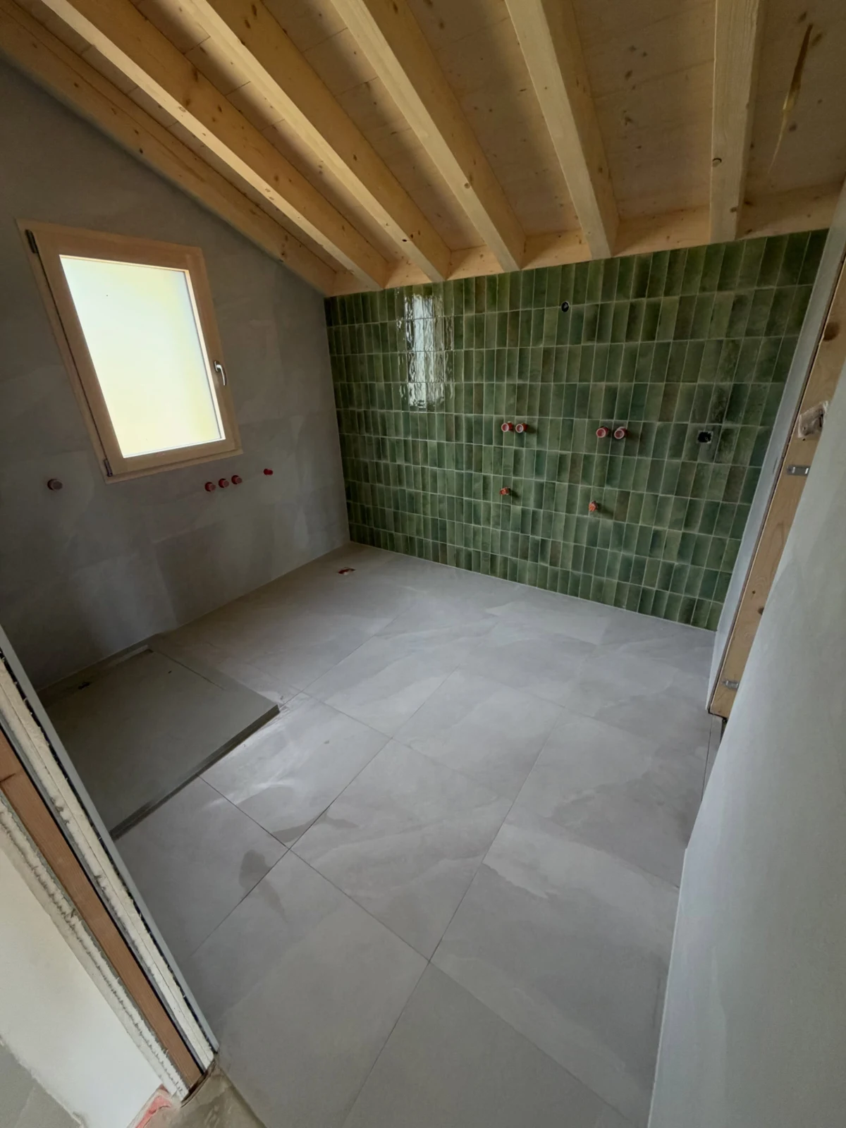 Salle de bains avec décor vert effet zellige et carrelage clair à Viuz-en-Sallaz